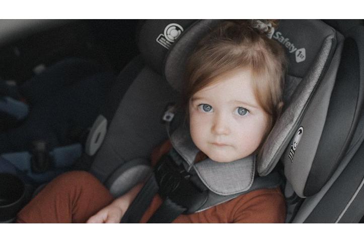 little girl buckled in a convertible car seat